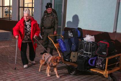 Una mujer que llegó de Kherson lleva a su perro en la estación de tren de Dzhankoi, en Crimea