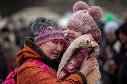 Una mujer que sostiene a un niño, llora después de huir de Ucrania y llegar al cruce fronterizo en Medyka, Polonia, el lunes 7 de marzo de 2022