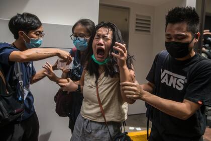 Una mujer reacciona al gas pimienta durante una protesta contra una nueva ley de seguridad nacional en Hong Kong