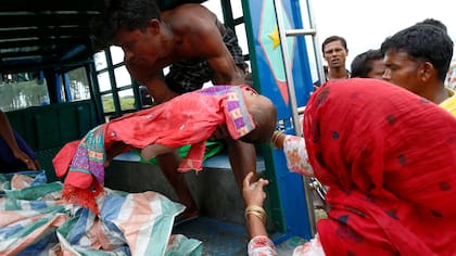Una mujer refugiada Rohingya carga el cuerpo de su hijo que murió después del naufragio del barco en el que viajaba en la Bahía de Bengala