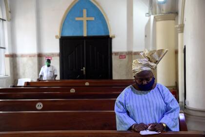 Una mujer reza en la Catedral de la Santa Cruz en Lagos, luego de la reapertura de iglesias y el levantamiento de las restricciones a las reuniones religiosas por parte del gobierno como precaución para controlar la propagación del coronavirus, el 9 de agosto de 2020
