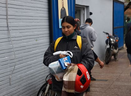 Una mujer sale de la unidad básica de Marcelo Sosa, uno de los candidatos a concejales de Insfrán, con una bolsa de comida, la boleta oficialista y el DNI