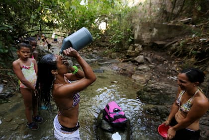 Una mujer se baña en uno de los arroyos que bajan del Parque Nacional El Ávila en Caracas, Venezuela