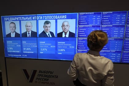 Una mujer se encuentra junto a una pantalla con los resultados preliminares de las elecciones presidenciales rusas en la Comisión Electoral Central en Moscú el 17 de marzo de 2024.