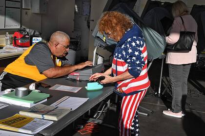 Una mujer se prepara para votar en un centro de votación del Condado de Orange durante las elecciones de 2020 en Huntington Beach, California