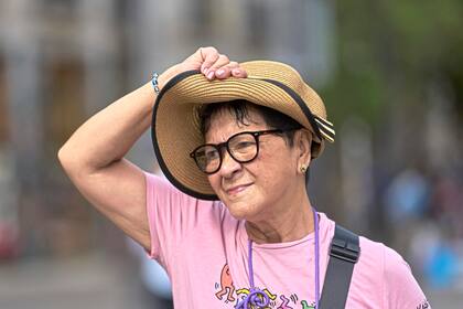 Una mujer se protege con su sombrero durante la ola de calor en Madrid