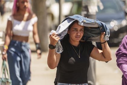 Una mujer se protege del sol en el distrito de Little Tokyo en Los Ángeles, el jueves 27 de julio de 2023. 