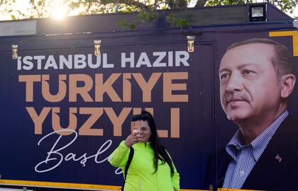 Una mujer se toma una selfie con un cartel del presidente turco y candidato presidencial de la Alianza Popular, Recep Tayyip Erdogan, en un mercado al aire libre en Estambul, Turquía, el lunes 8 de mayo de 2023. El texto en turco dice "Estambul está lista, comienza el siglo de Turquía"