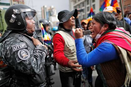 Una mujer seguidora del ex presidente de Bolivia, Evo Morales, le grita a un oficial de policía y le dice que respete a los pueblos indígenas de la nación