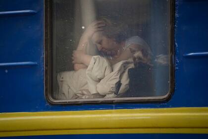 Una mujer, sentada junto a la ventana de un tren con destino Lviv, en Kiev, Ucrania, el 3 de marzo de 2022. (AP Foto/Vadim Ghirda)