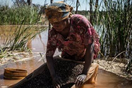 Una mujer separa cobalto del barro y rocas cerca de una mina en la RDC