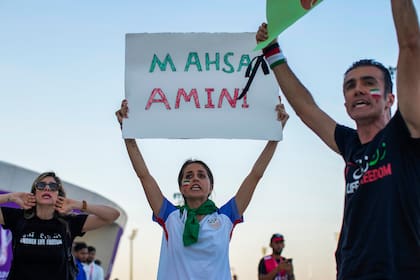 Una mujer sostiene un cartel con el nombre de Mahsa Amini, durante una protesta después del un partido del Mundial entre Gales e Irán