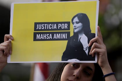 Una mujer sostiene un cartel que dice en español "Justicia para Mahsa Amini" mientras protesta contra la muerte de Amini, una mujer iraní que murió mientras estaba bajo custodia policial en Irán