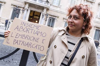 Una mujer sostiene un cartel que dice en italiano "Abortemos juntos el embrión y el patriarcado", frente al Senado italiano en Roma, el 22 de abril de 2024. (Roberto Monaldo /LaPresse via AP)
