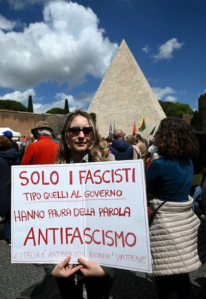Una mujer sostiene un cartel que dice "sólo los fascistas, como nuestros gobernadores, tienen miedo de la palabra antifascismo. Italia es antifascista, Giorgia vete a casa", mientras participa en una manifestación organizada por la Asociación Nacional de Partidarios Italianos (Anpi ) con motivo del 79.º aniversario del Día de la Liberación
