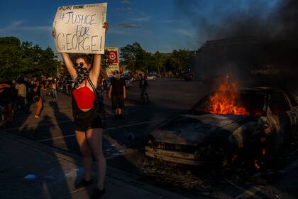 Una mujer sostiene un cartel que se lee "Justicia para George" en Minneapolis