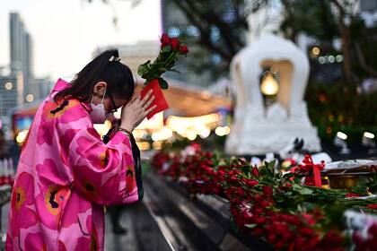 Una mujer sostiene un ramo de rosas rojas mientras ofrece oraciones en el Día de San Valentín en el Santuario Trimurti en Bangkok, Tailandia