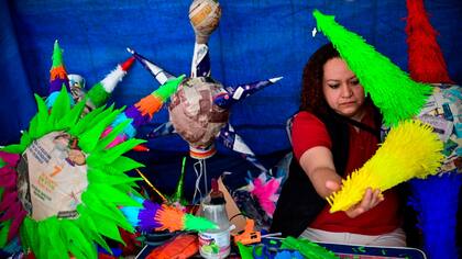 Una mujer trabaja en el armado de una clásica piñata mexicana