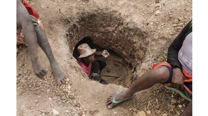 Una mujer trabajadora de la mina, observa una gema encontrada