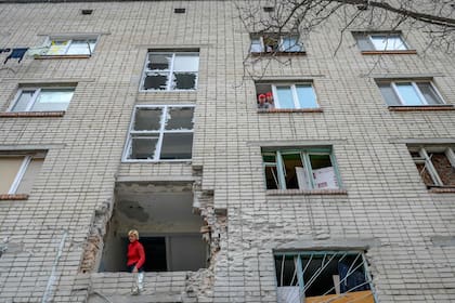 Una mujer ucraniana mira desde un edificio dañado que fue alcanzado por un mortero ruso en Mykolaiv, a 100 km de Odessa, en el oeste de Ucrania
