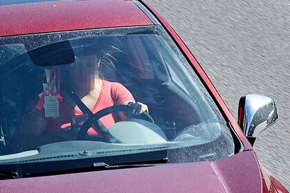 Una mujer usa el teléfono celular al conducir, otra de las acciones temerarias registradas en el informe de seguridad vial