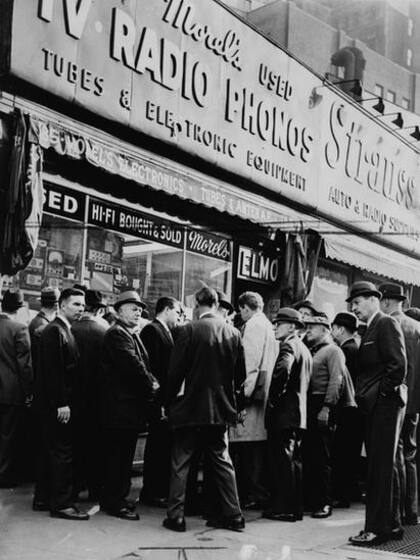 Una multitud congregada ante un comercio en Radio Row para escuchar las noticias sobre el asesinato del presidente John F. Kennedy