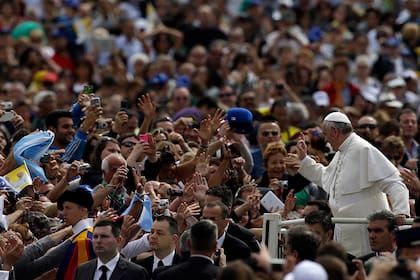 Una multitud de fieles anima cuando el Papa Francisco da la señal de aprobación mientras recorre la Plaza de San Pedro en su móvil durante su audiencia general semanal en el Vaticano, el miércoles 15 de mayo de 2013.