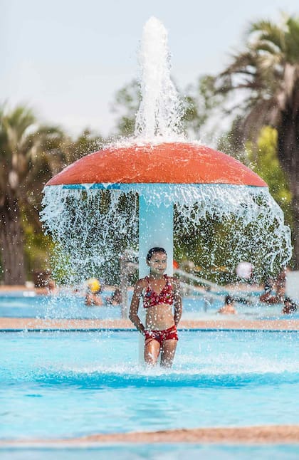 Una niña bajo una ducha con forma de hongo en el Complejo Termal Guaviyú.