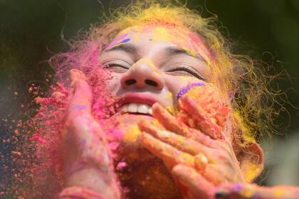 Una niña es manchada con pintura en polvo durante el Festival Holi, también conocido como festival de los colores en la India