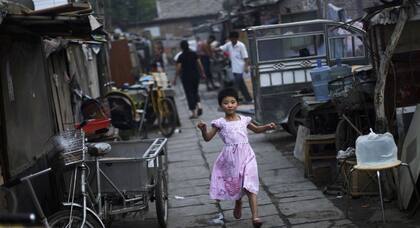 Una niña juega en uno de los hutongs (callejones con casas bajas) que todavía subsisten en Pekín.