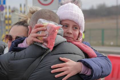 Una niña que huyó de la guerra en Ucrania se reúne con su padre después de cruzar la frontera en Medyka, sureste de Polonia, el miércoles 2 de marzo de 2022