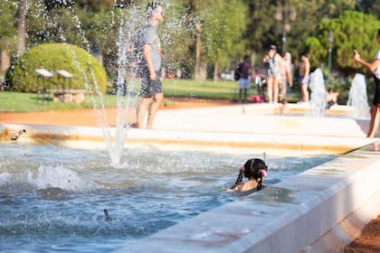 Una niña se baña en una fuente pública para tratar de sofocar el calor extremo de marzo