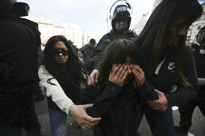 Una niña se ve afectada por gases lacrimógenos rociados por la policía antidisturbios durante una protesta frente al Congreso Nacional en Buenos Aires el 11 de septiembre de 2024.