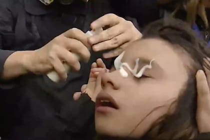 Una niña se ve afectada por gases lacrimógenos rociados por la policía antidisturbios durante una protesta frente al Congreso Nacional en Buenos Aires el 11 de septiembre de 2024.