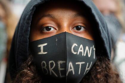 Una niña usa una máscara facial durante un mitin de Black Lives Matter en Parliament Square, en Londres, el sábado 6 de junio de 2020, mientras protestan contra el asesinato de George Floyd por agentes de policía en Minneapolis, EE. UU.