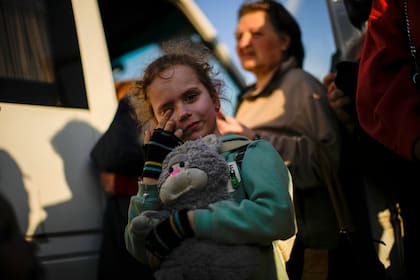 Una niña y su familia que huyeron de la ciudad de Mariúpol llegan a un centro de recepción de personas desplazadas el domingo 8 de mayo de 2022, en Zaporiyia, Ucrania. (AP Foto/Francisco Seco)