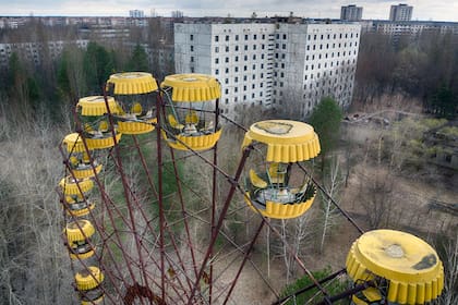 Una noria abandonada en el pueblo fantasma de Pripyat, cerca de la central nuclear de Chernóbil, en Ucrania, el jueves 15 de abril de 2021. (AP Foto/Efrem Lukatsky)