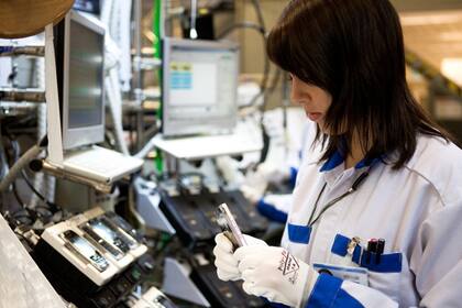 Una operaria examina un celular en la fábrica de Nokia ubicada en Salo, Finlandia. La compañía anunció la producción en Tierra del Fuego con un socio local