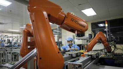 Una operaria junto a un robot de la fábrica Rapoo, en la ciudad de Shenzen, en el sur de China.
