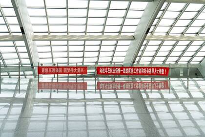 Una pancarta de propaganda cuelga dentro del Aeropuerto Internacional de Pekín el 3 de febrero de 2020. El cartel dice "¡Felicitaciones a todos los trabajadores médicos que luchan contra la epidemia en la primera línea y a todos los voluntarios de la sociedad!"