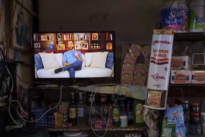 Una pantalla de televisión muestra un anuncio de campaña que promociona al presidente de El Salvador, Nayib Bukele, quien se postula para la reelección, en el mercado de Santa Tecla