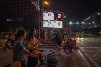 Una pantalla en el exterior en Xiangyang muestra fotos de las personas que cruzan la calle en lugares no permitidos junto a sus nombres y números de identidad. La idea es avergonzar a los infractores para que respeten la ley