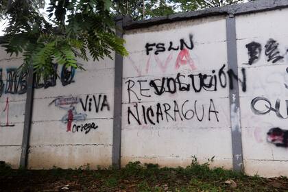 Una pared pintada con graffitis con un mensaje que alguna vez decía en español: "Resiste Nicaragua", fue pintado por otro que ahora dice "Viva la revolución" en Managua