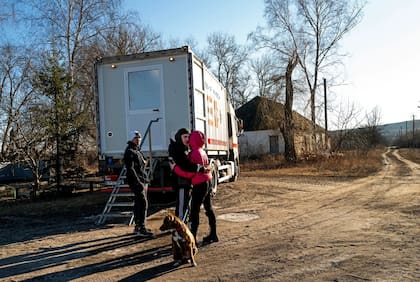 Una pareja abrazándose mientras espera ver a un médico en el camión médico móvil en la región de Kharkiv. Si bien la guerra no está lejos de la mente de la gente, la mayoría de los aldeanos están preocupados por asuntos más cotidianos. (Foto: Lynsey Addario para The New York Times)