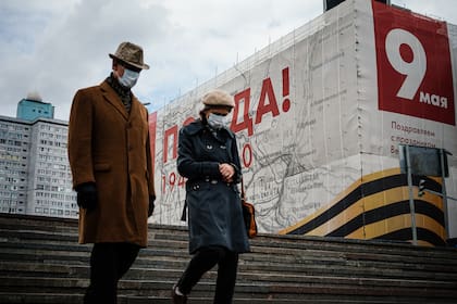 Una pareja con barbijos camina en el centro de Moscú el 7 de mayo de 2020, en plena pandemia de coronavirus