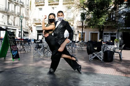 Una pareja de bailarines de tango dan su show a pesar de que no haya turistas en la Plaza Dorrego