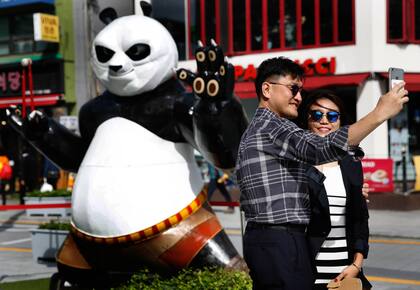 Una pareja de turistas se toma una selfie con Kung Fu Panda en Seúl.
