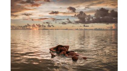 Una pareja disfruta en la playa al atardecer