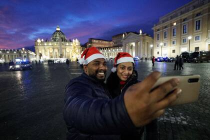 Una pareja se saca una selfie en una vacía y atípica plaza de San Pedro, en el Vaticano