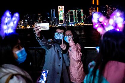 Una pareja se toma una selfie junto al puerto de Victoria Harbour en Hong Kong